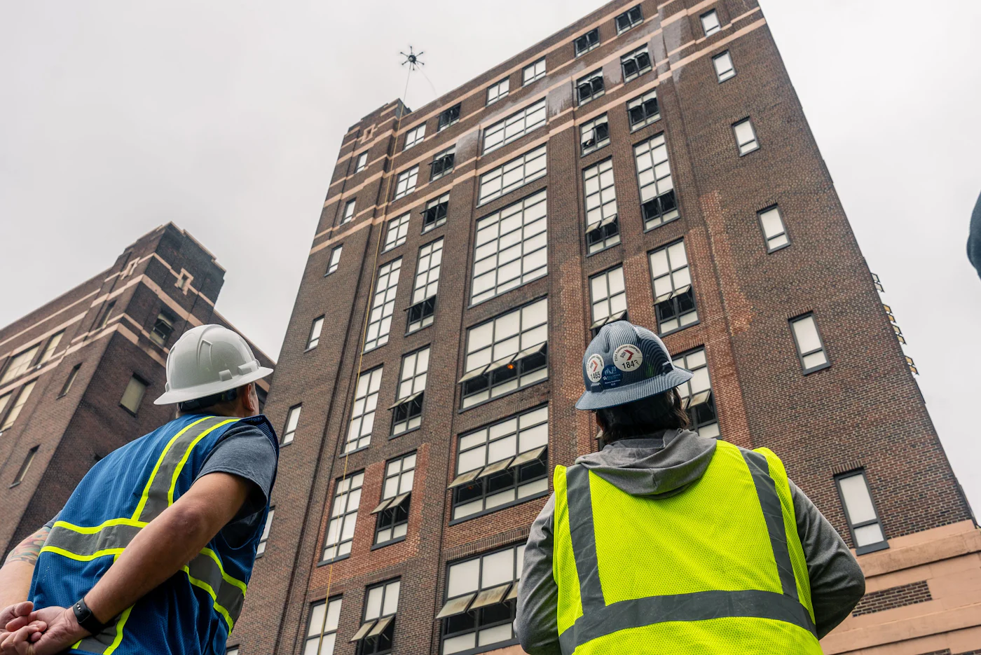 Godwin Facility Services crew in safety vests watching the cleaning drone at the Domino Sugar refinery